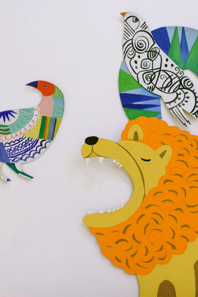 pexels-photo-8535224-8535224 Vibrant paper cutouts of a lion and birds in artistic design.